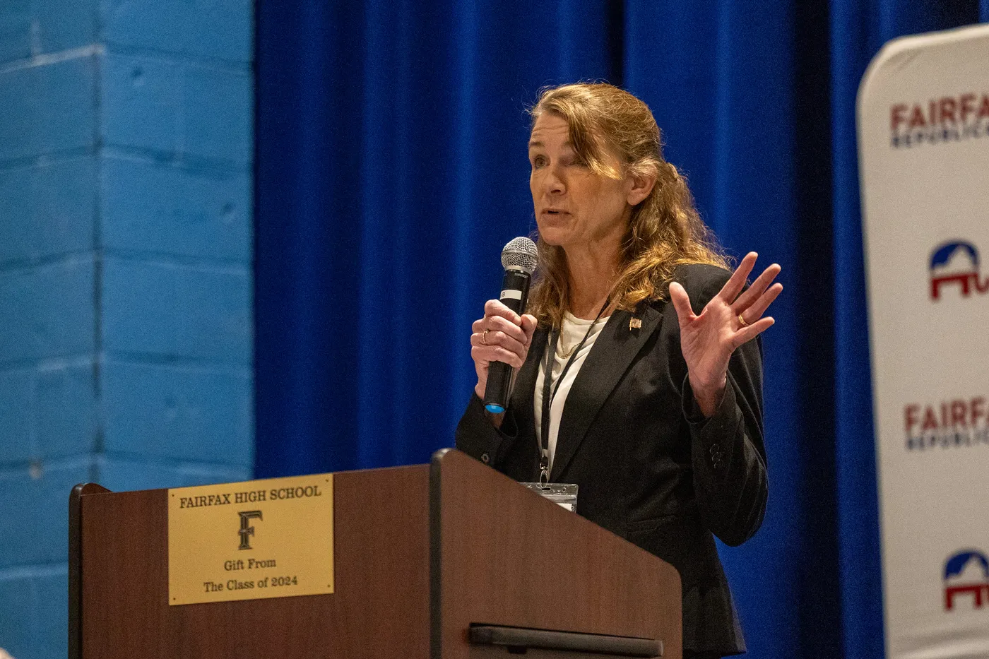 A committee leader speaks and gestures from the Fairfax Republicans podium at the 2026 County Convention.