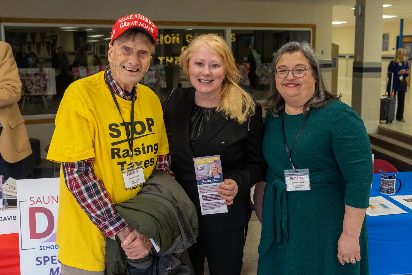 Attendees at the 2026 County Convention, one wearing a yellow 'Stop Raising Taxes' campaign shirt.