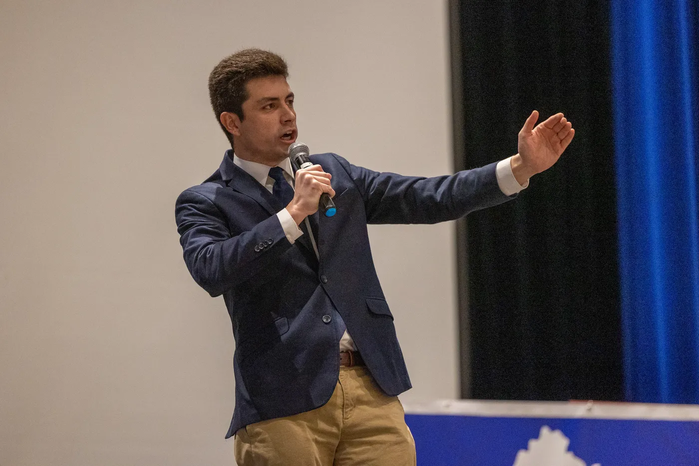 A young Republican speaks to the 2026 Fairfax County Republican Convention, mid-gesture.